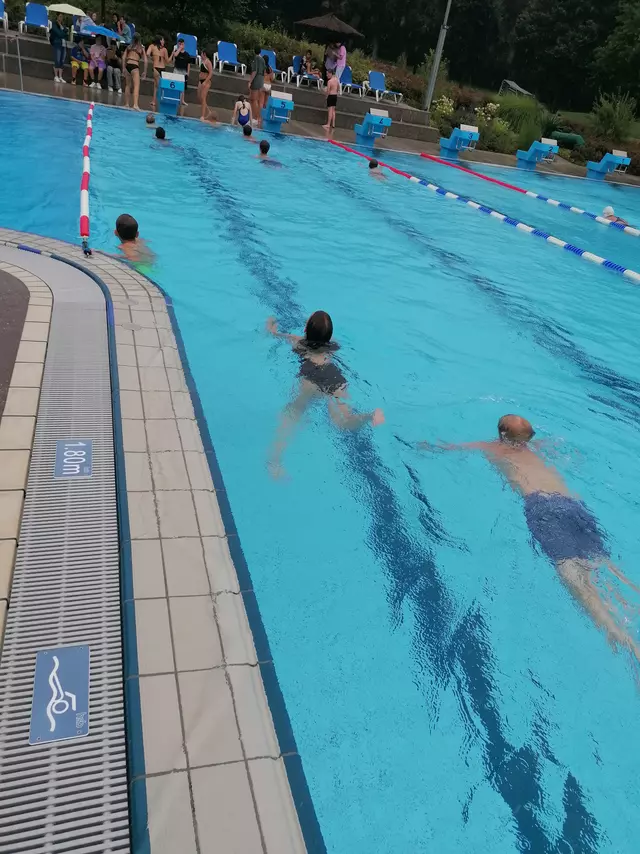 Schüler schwimmen Bahnen im Freibad